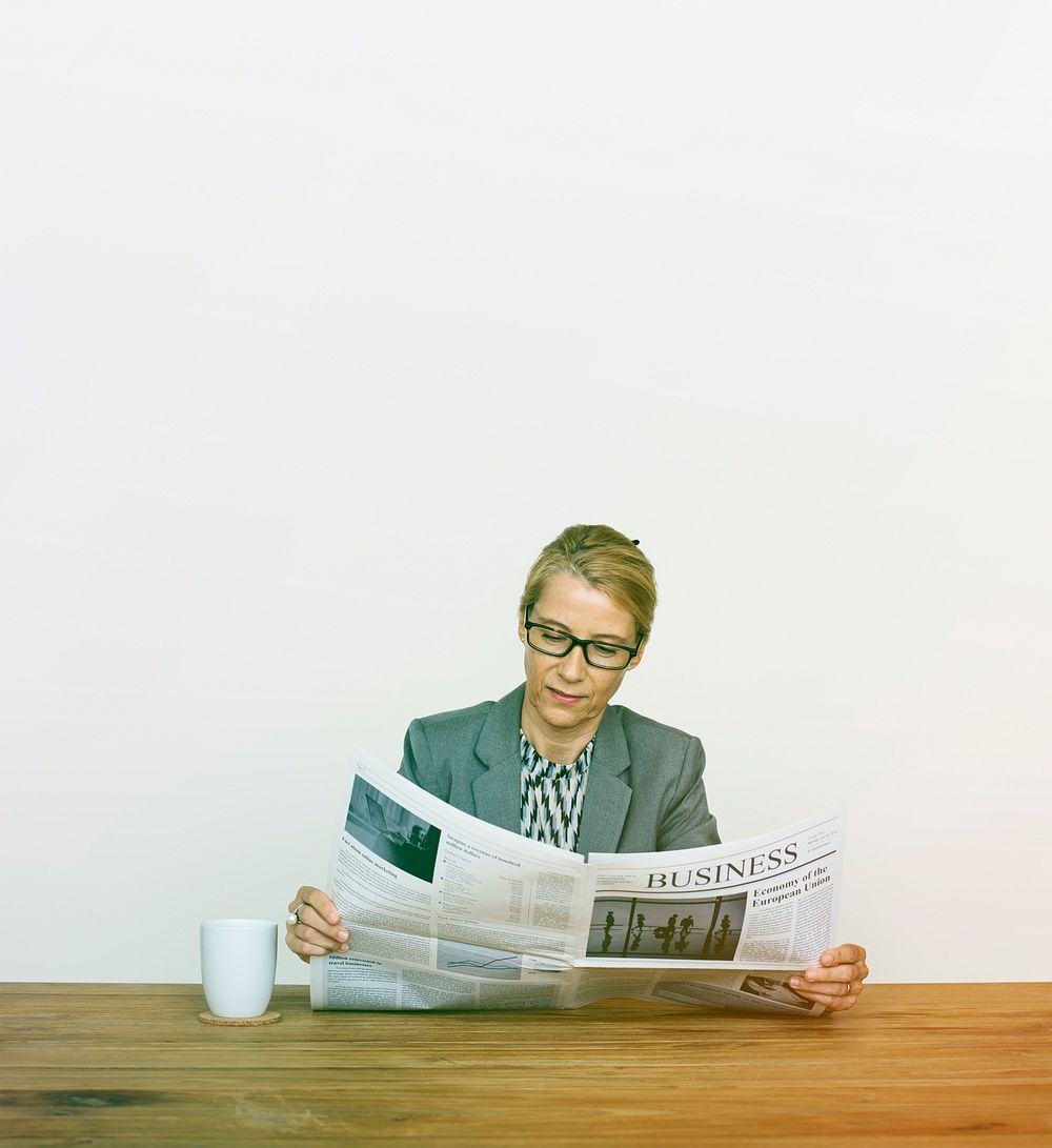 Businesswoman Reading Newspaper For Information