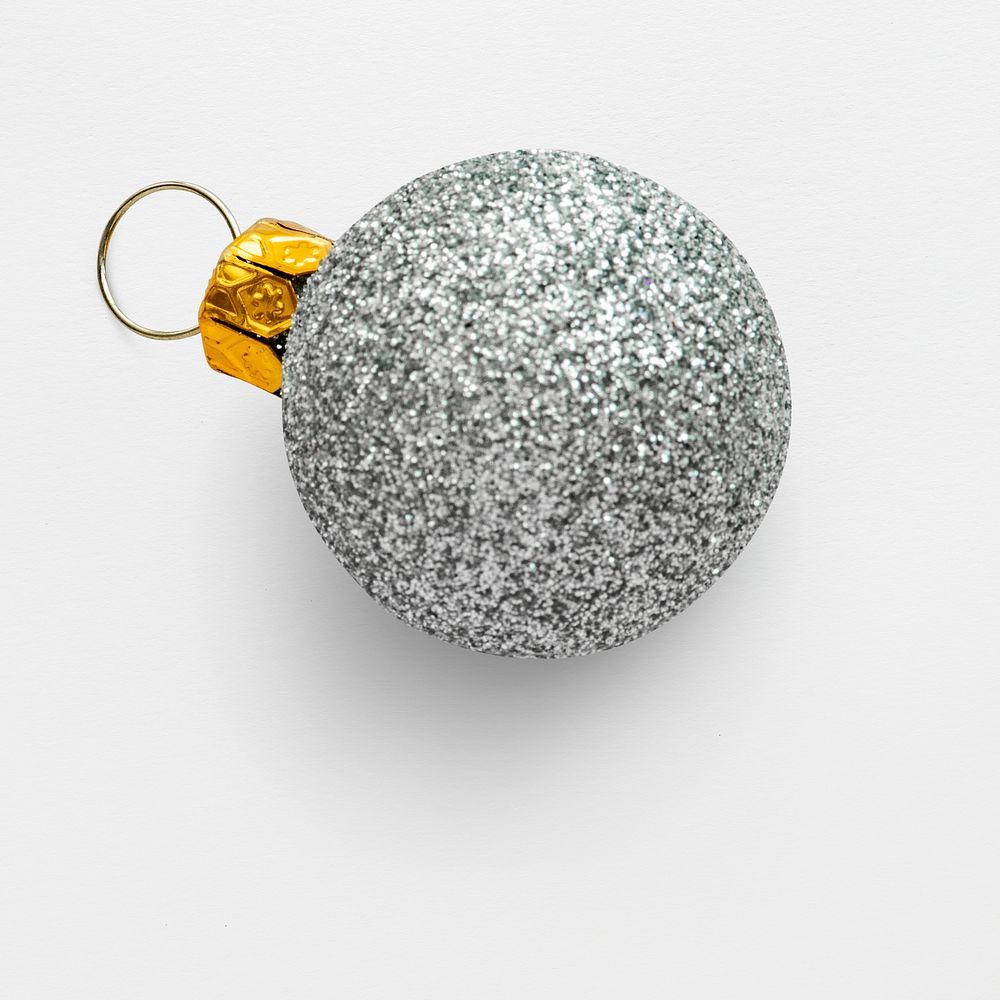 A glitter silver ball Christmas ornament isolated on gray background