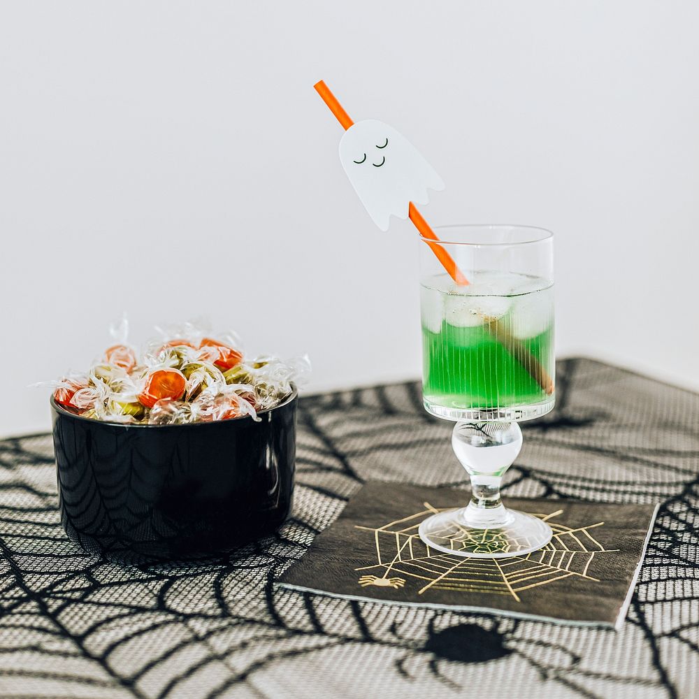 Halloween party with a drink and a bowl of candies on the table 