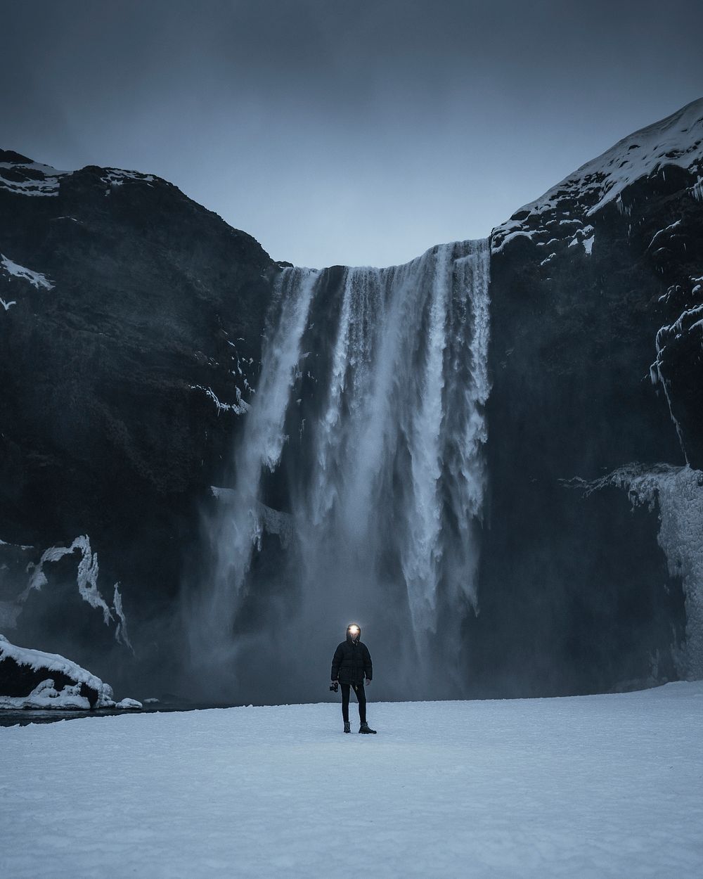 Woman standing infront of Skogafoss waterfall on Iceland