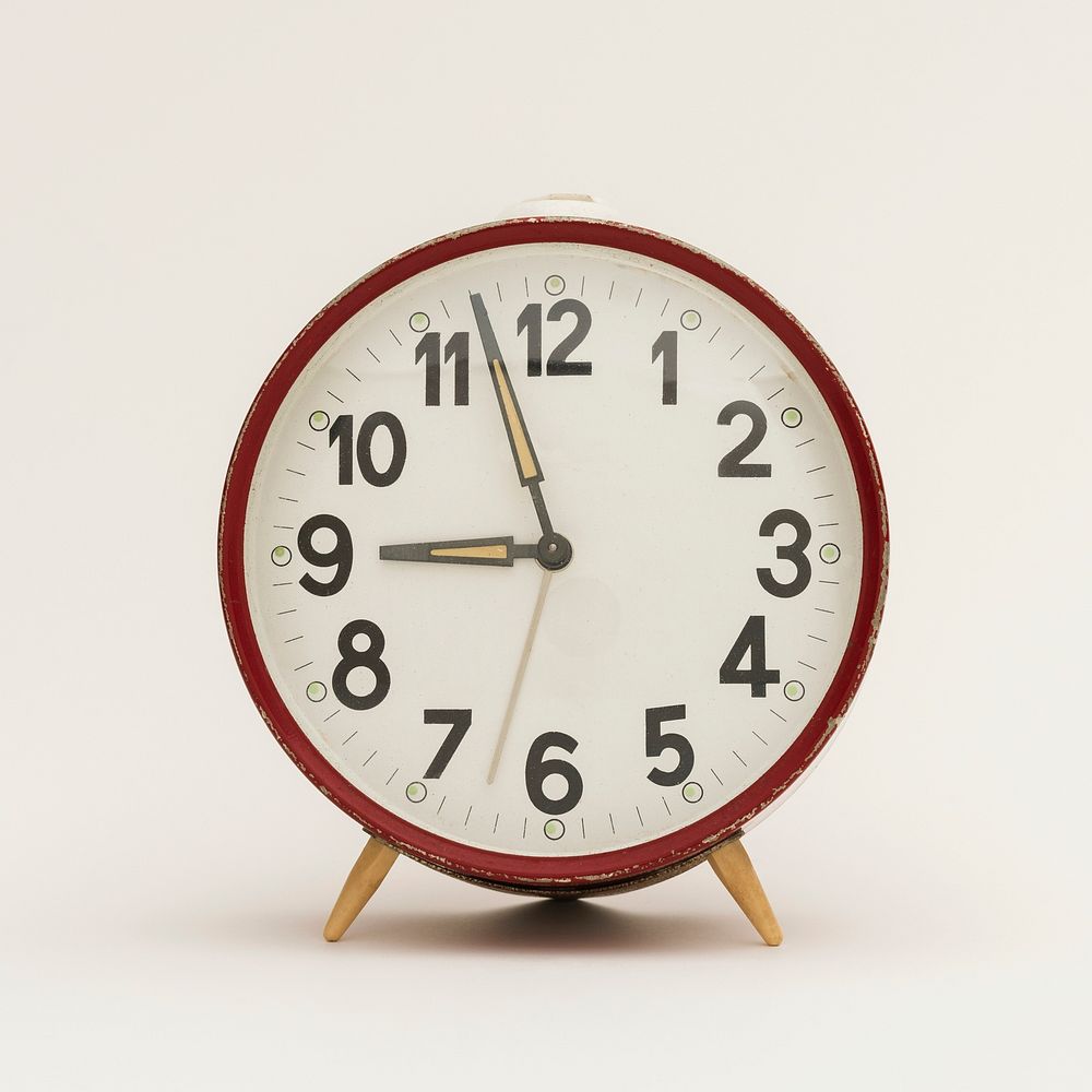 Vintage analog alarm clock on a beige background