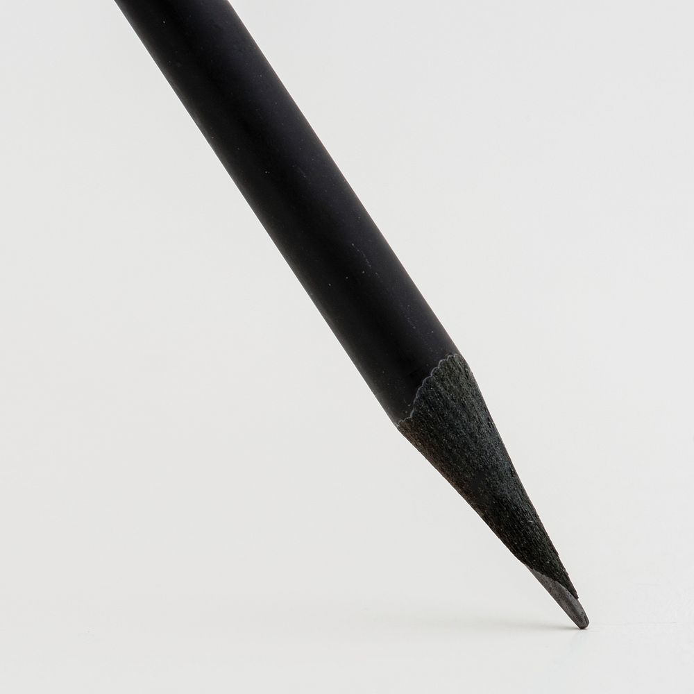 Black wooden pencil on off white background
