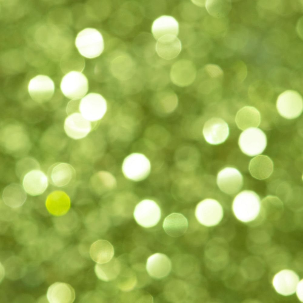 Shiny blurry green glitter textured background