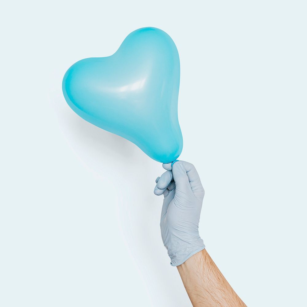 Gloved hand holding a blue heart shaped balloon mockup on a blue background