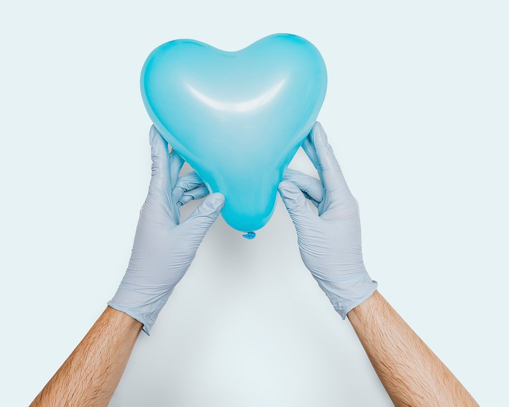 Gloved hands holding a blue heart shaped balloon mockup on a blue background