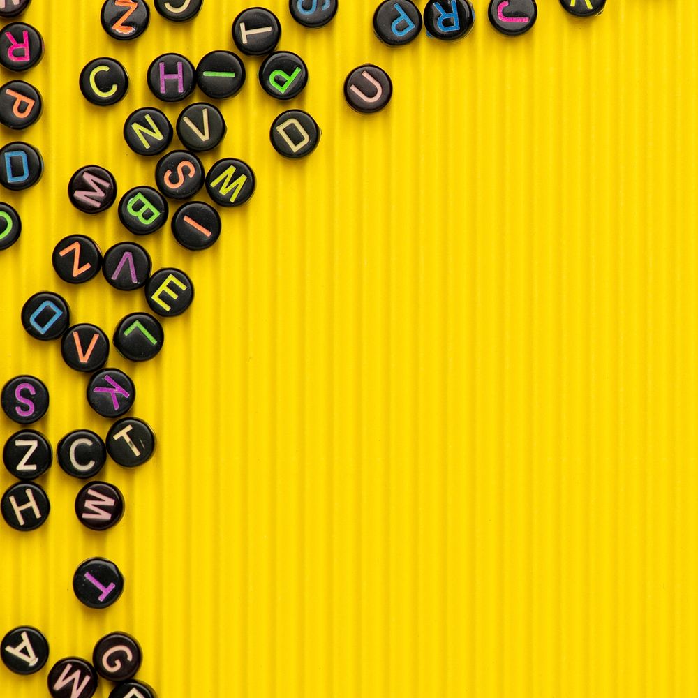 Black alphabet beads border on yellow background