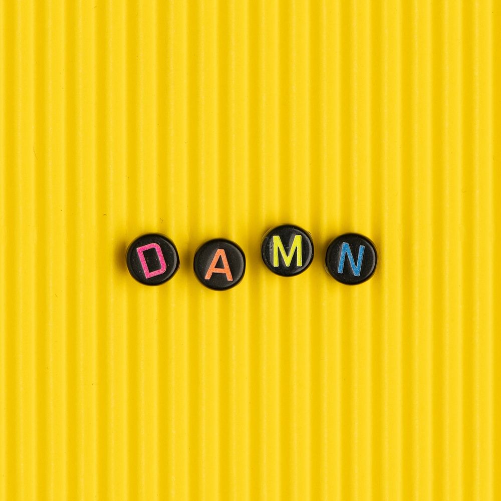 DAMN beads word typography on yellow