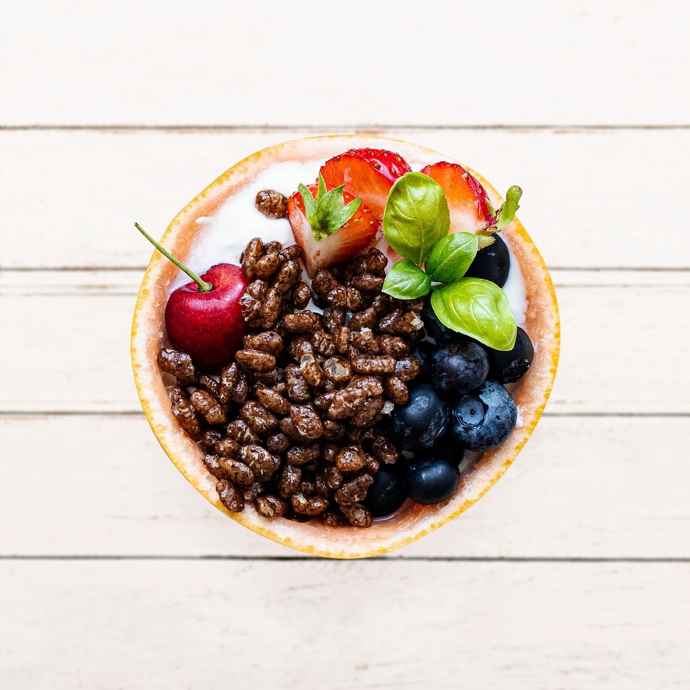 Kids breakfast cereal bowl with berries and yogurt