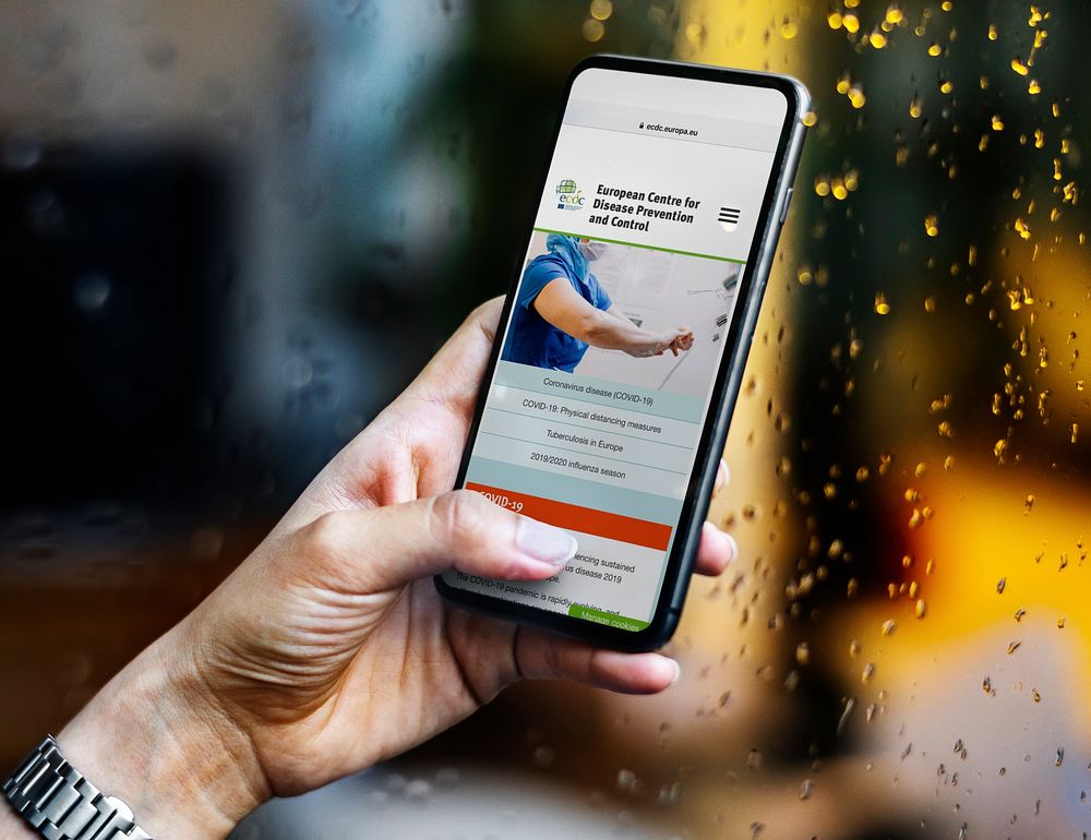 Woman reading coronavirus information from a phone mockup with editorial graphic from https://www.ecdc.europa.eu/en accessed…