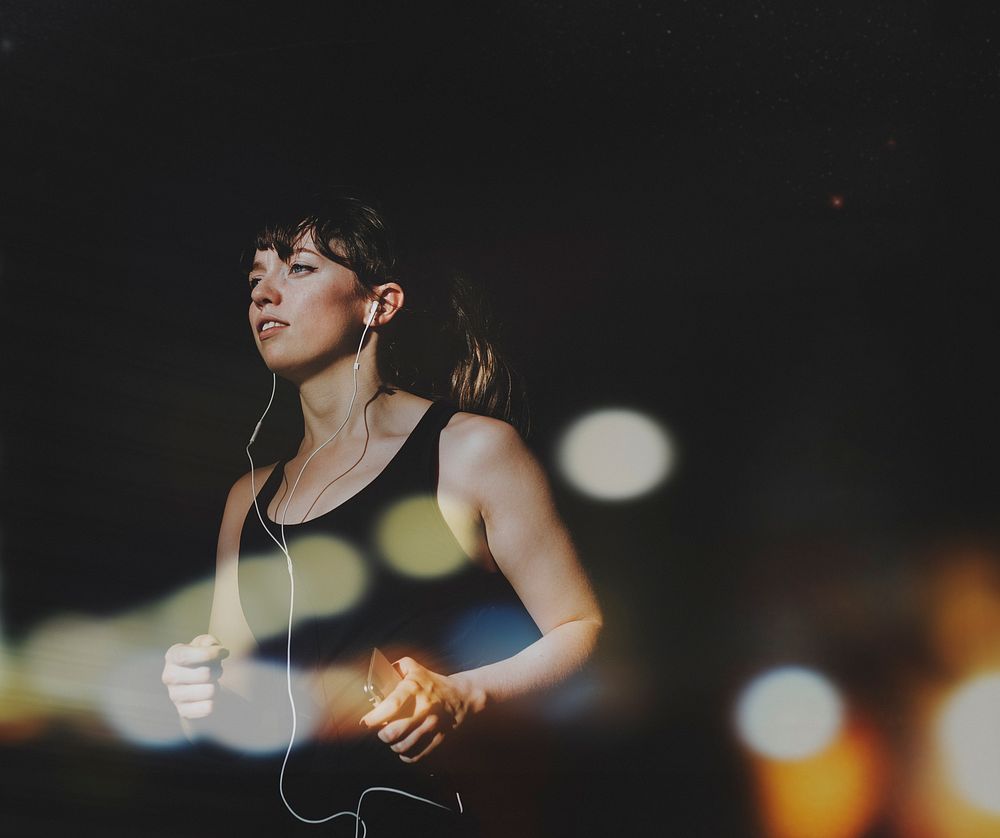 Sporty woman running in a dark alley