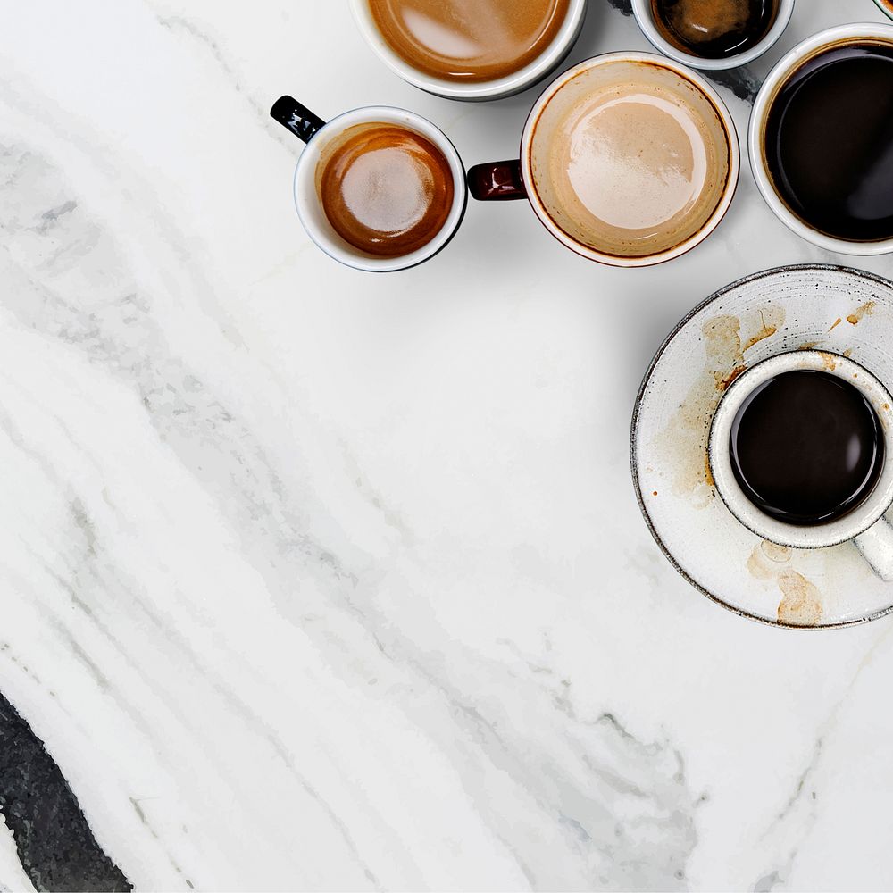 Mixed coffee cups on a black and white marble textured wallpaper