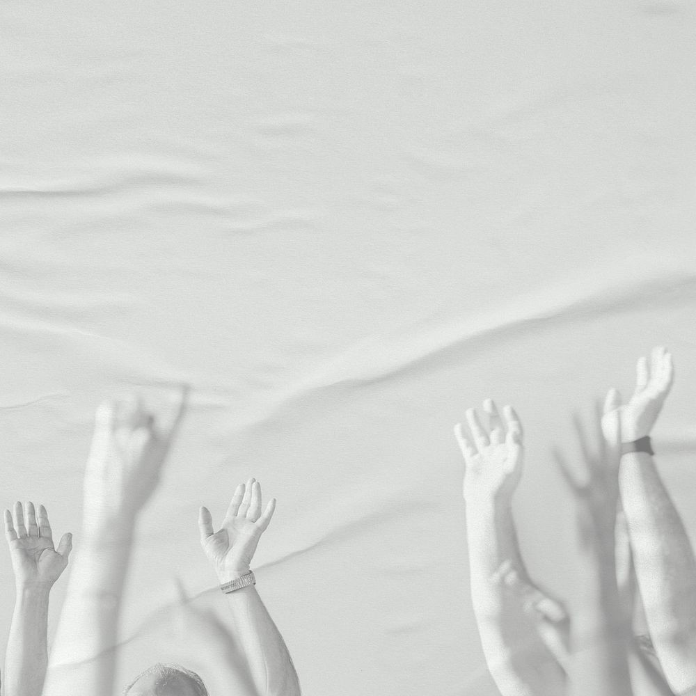 White arms raising on paper textured background