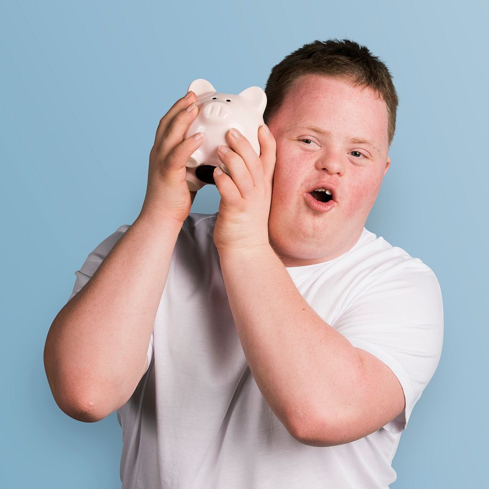 Young man with Down syndrome checking his piggy bank