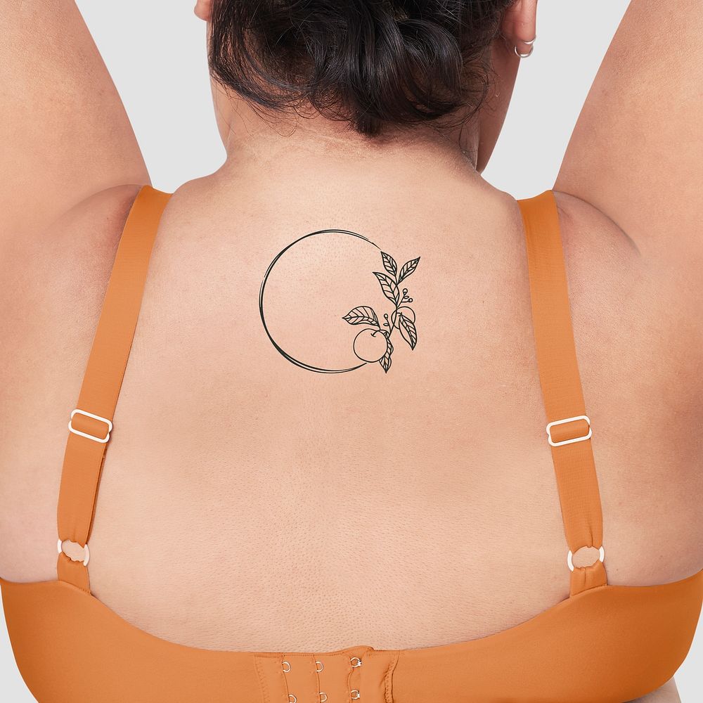 Plus size model orange bra with floral tattoo closeup
