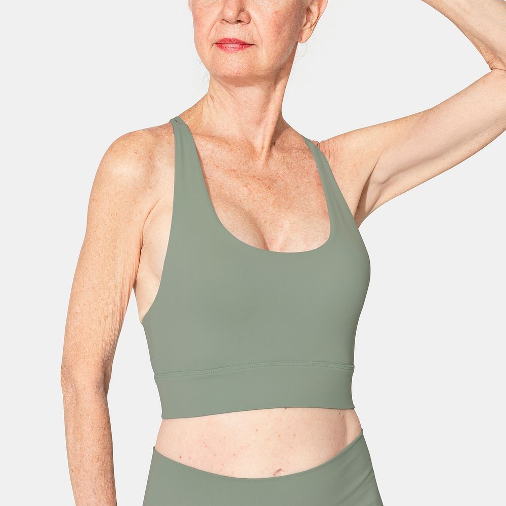 Healthy senior woman in green sports bra and leggings