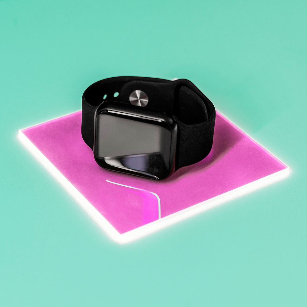 Smartwatch charging on pink transparent plate