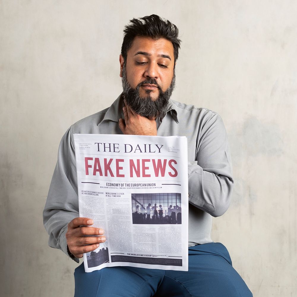 Doubtful Indian man reading the newspaper with fake news 