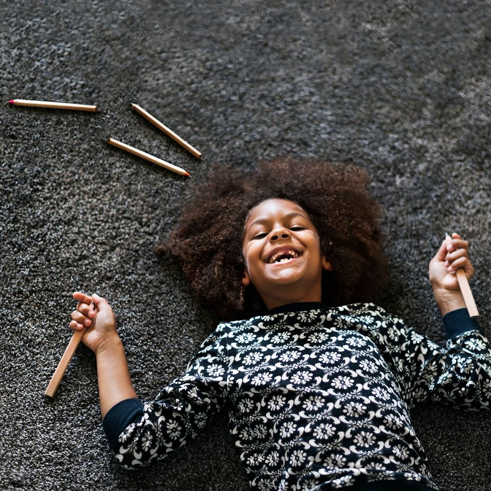 Happy African American girl lying on the floor