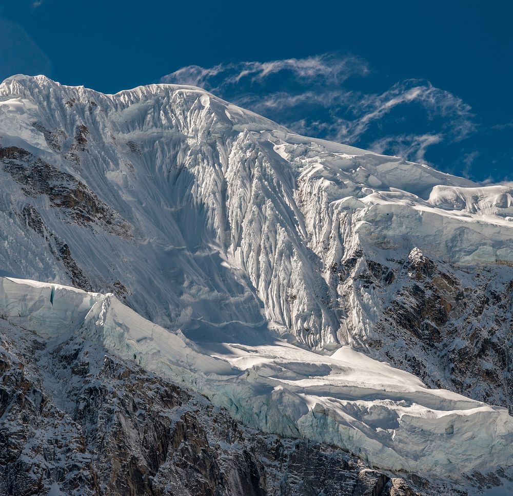 A steep icy face beneath a snowy mountain's crest. Original public domain image from Wikimedia Commons