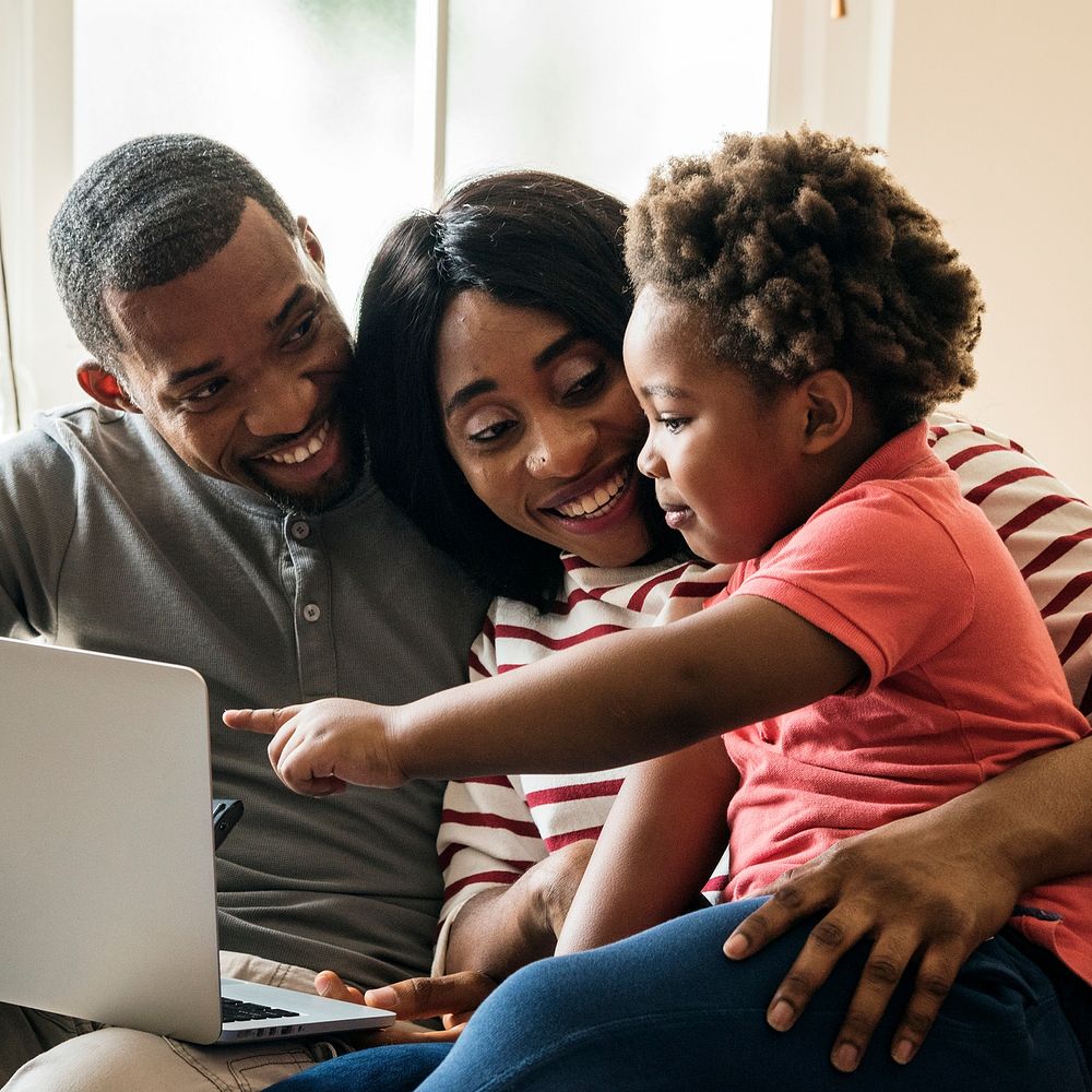 Happy black family and toddler pointing at a laptop screen