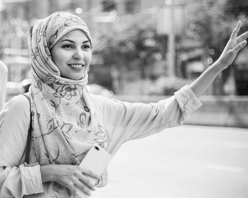 Islamic woman calling taxi in the city