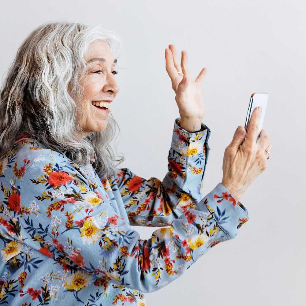 Happy woman waving hello to a smartphone