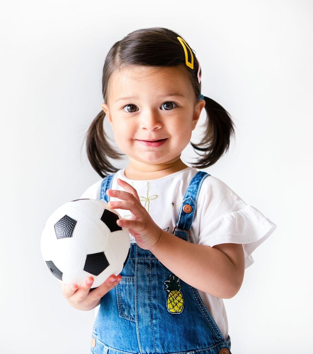 Happy little girl holding a football
