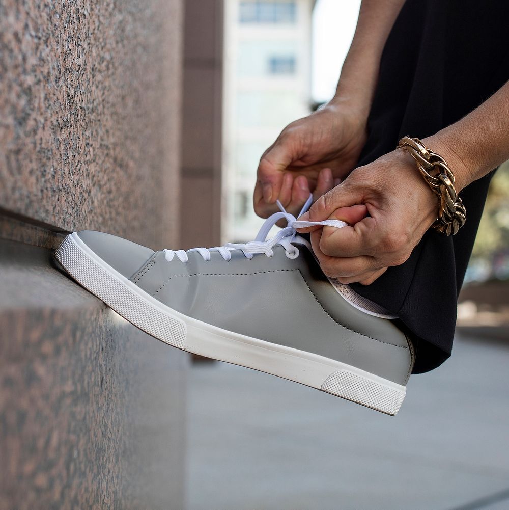 Canvas sneakers gray model tying shoelaces apparel ad