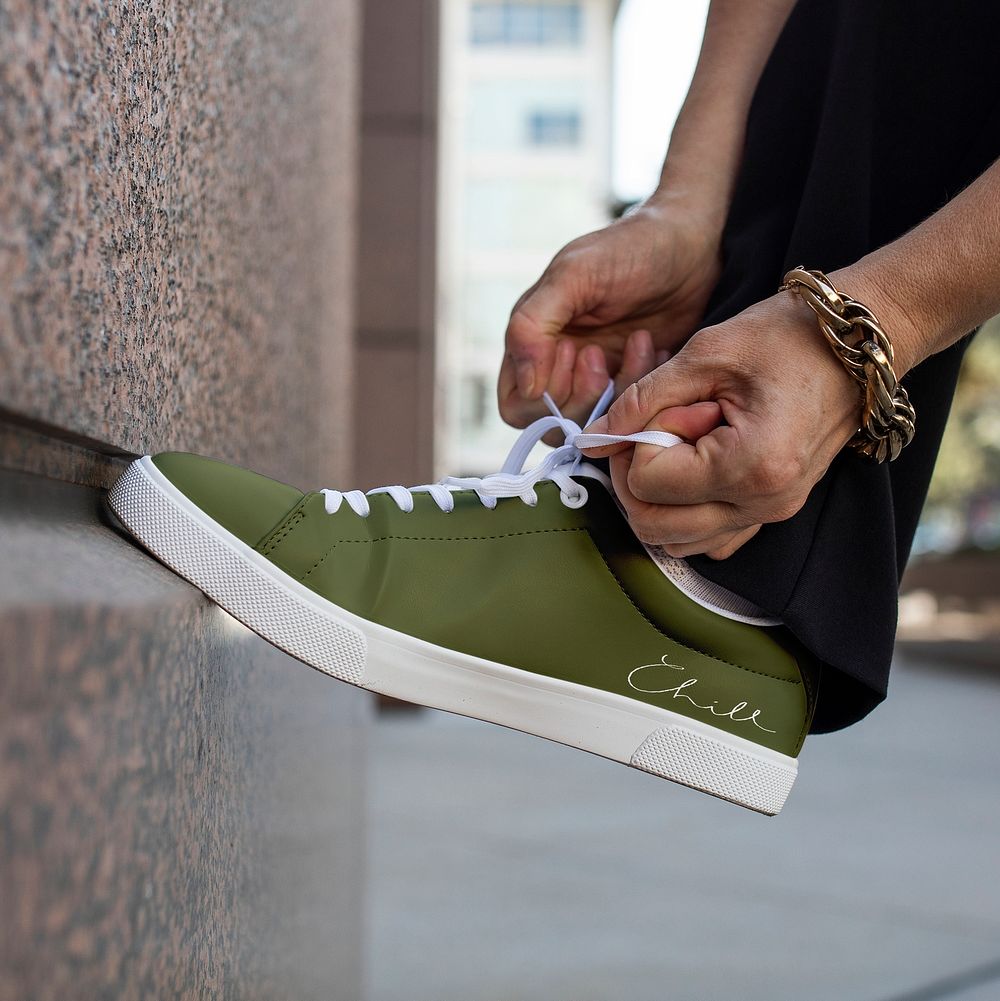 Canvas sneakers green model tying shoelaces apparel ad
