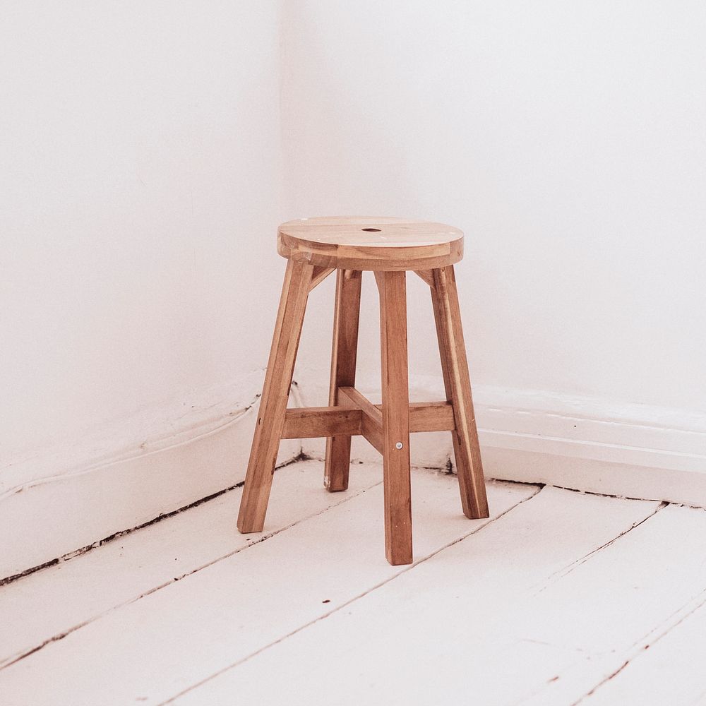 Wooden bar stool in a corner