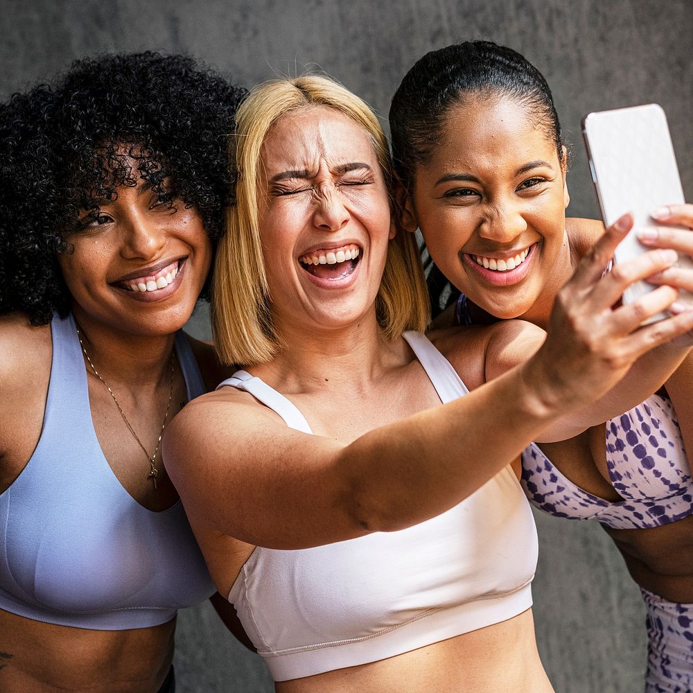 Cheerful sporty women taking a selfie at the gym