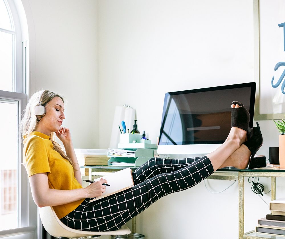 Casual woman in an office with headphones