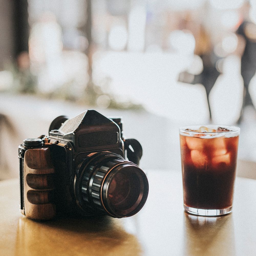 Iced Americano and an analog 120mm camera at a cafe table