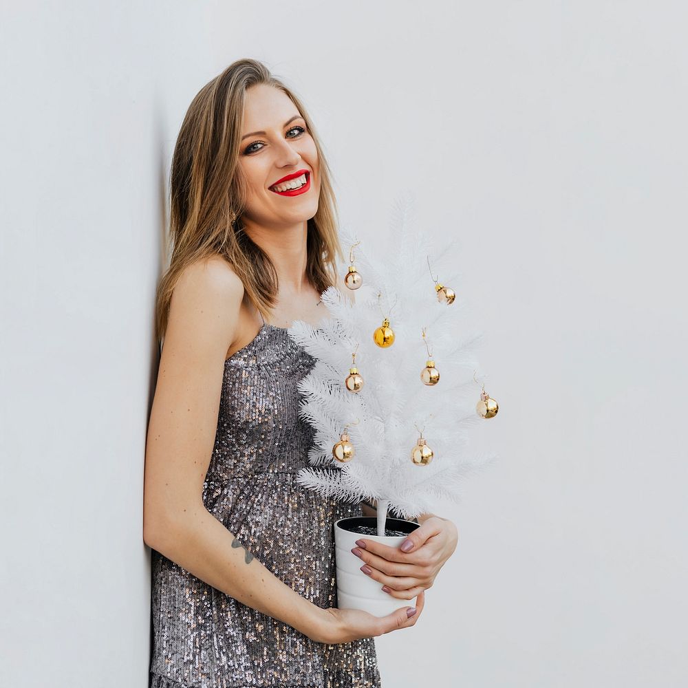 Woman holding a small white Christmas tree