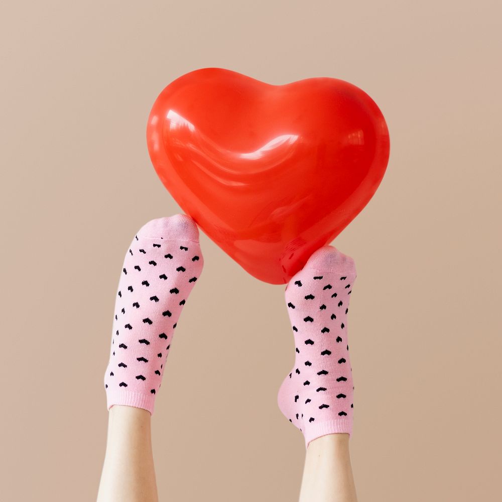 Red heart balloon on a feet with socks
