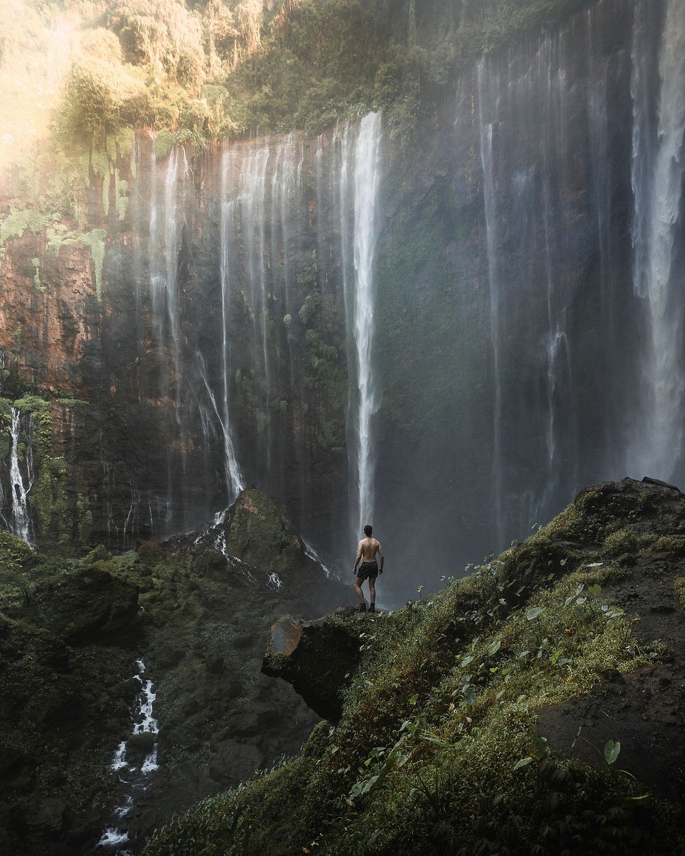 Man standing by Tumpak Sewu Waterfalls, Indonesia
