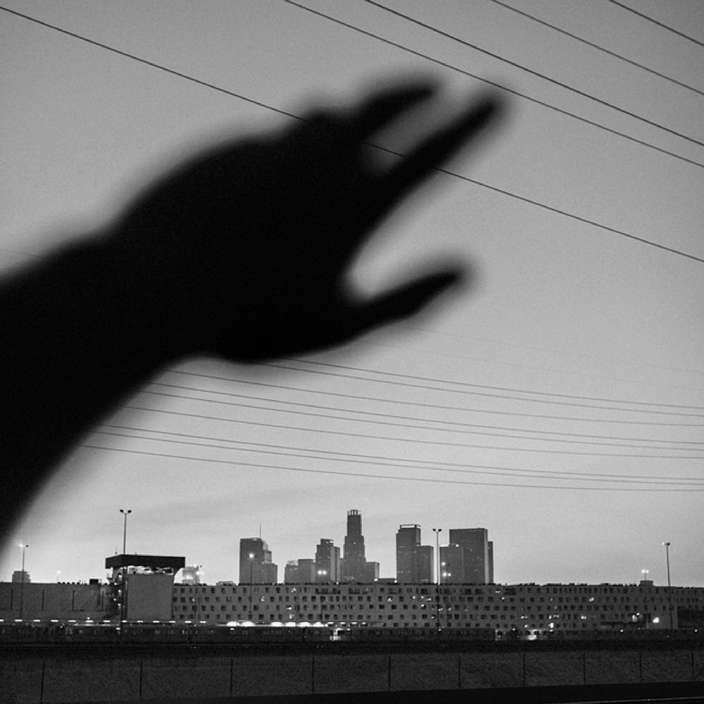 Hand reaching shadow, cityscape black and white