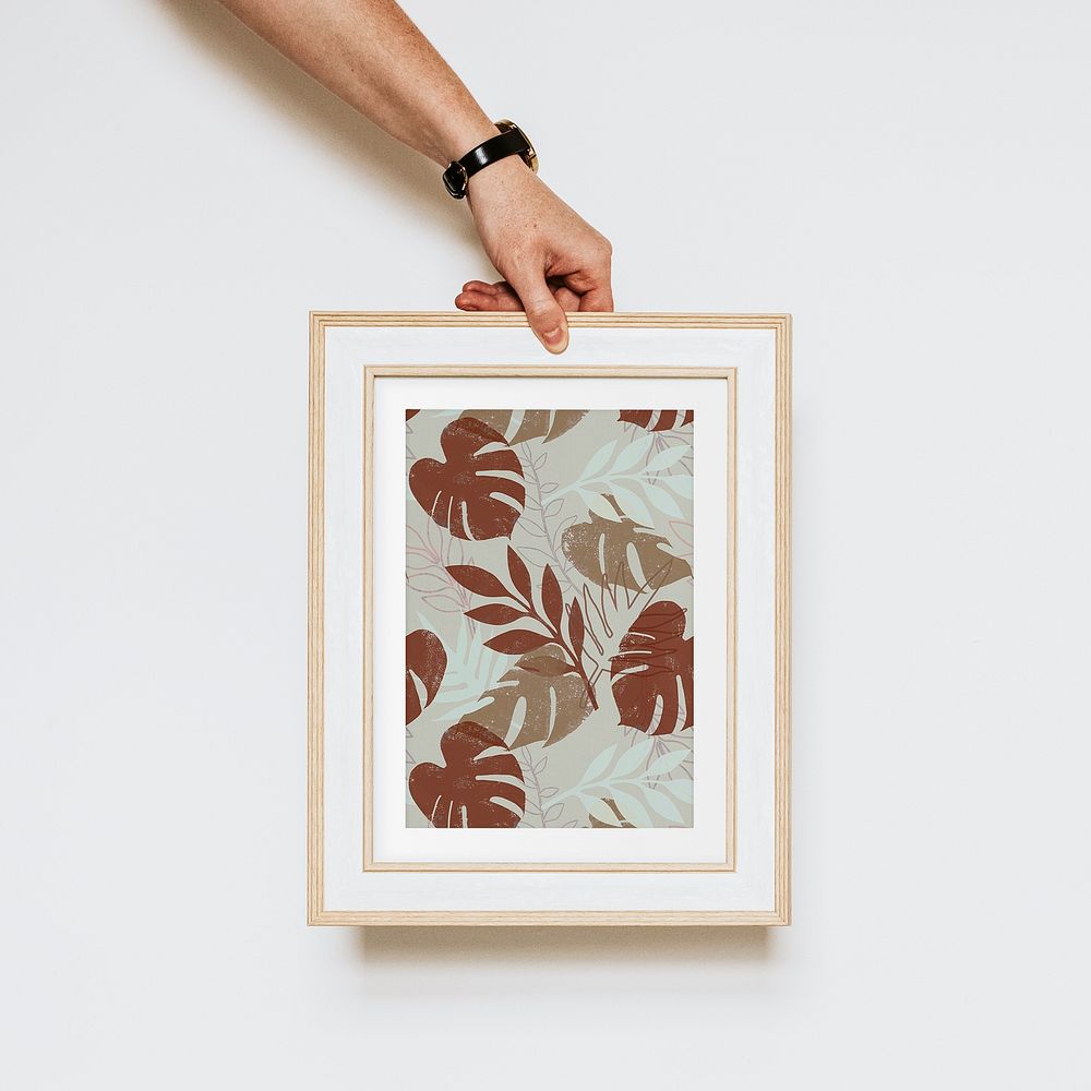 Hand holding aesthetic leaf photo frame