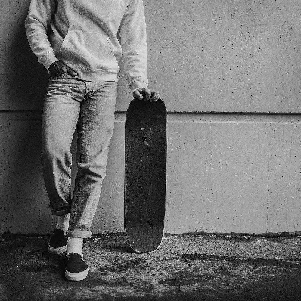 Male skateboarder in sweater, jeans in black and white