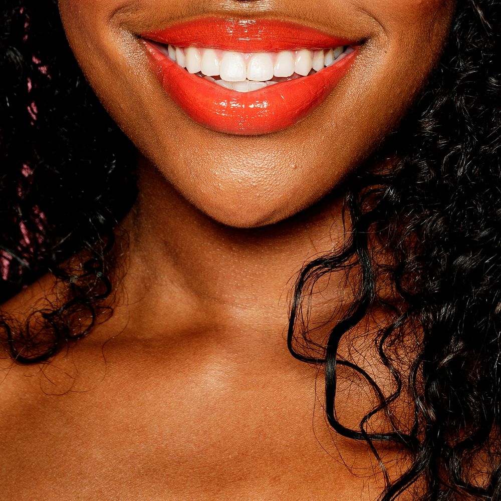 Happy black woman wearing peach lip gloss 