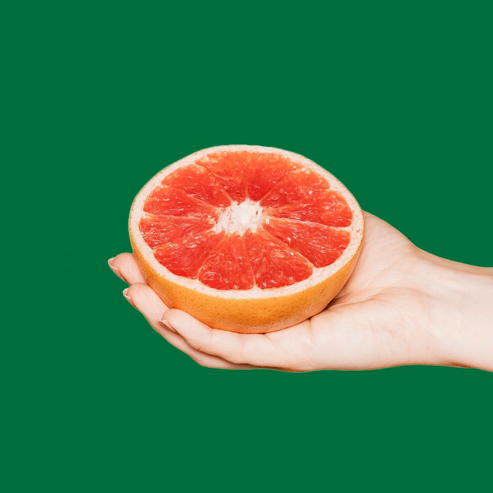 Woman holding grapefruit, green background