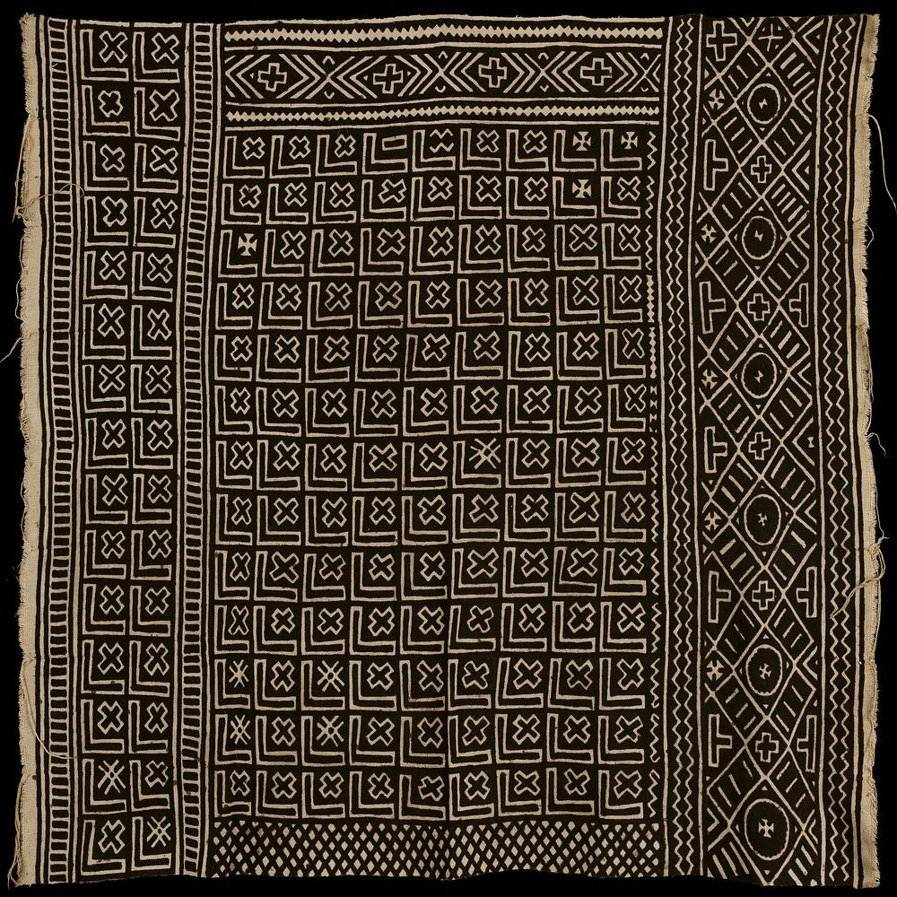 black and tan textile; constructed of eight long strips stitched together; short edges have fringe; textile is decorated…