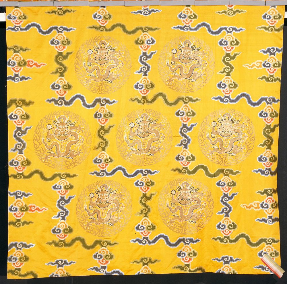 curtain hanging of imperial yellow brocaded satin. design of seven gold-cloud medallions, each with a five-clawed dragon…