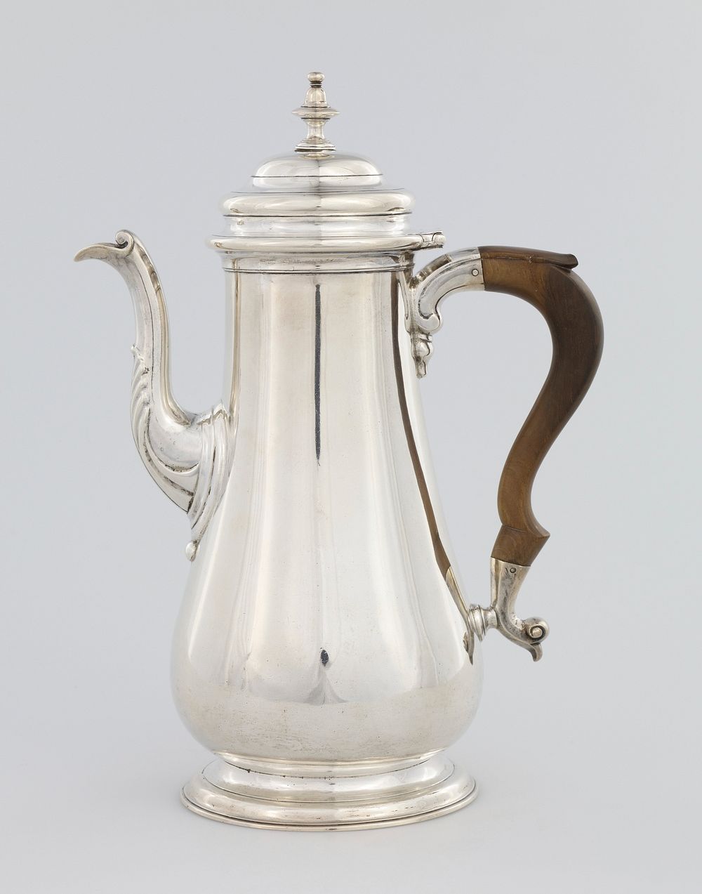 pyriform coffee pot, tall, plain, pear-shaped with molded foot, low dome cover and knopped finial; scrolled spout wrought…