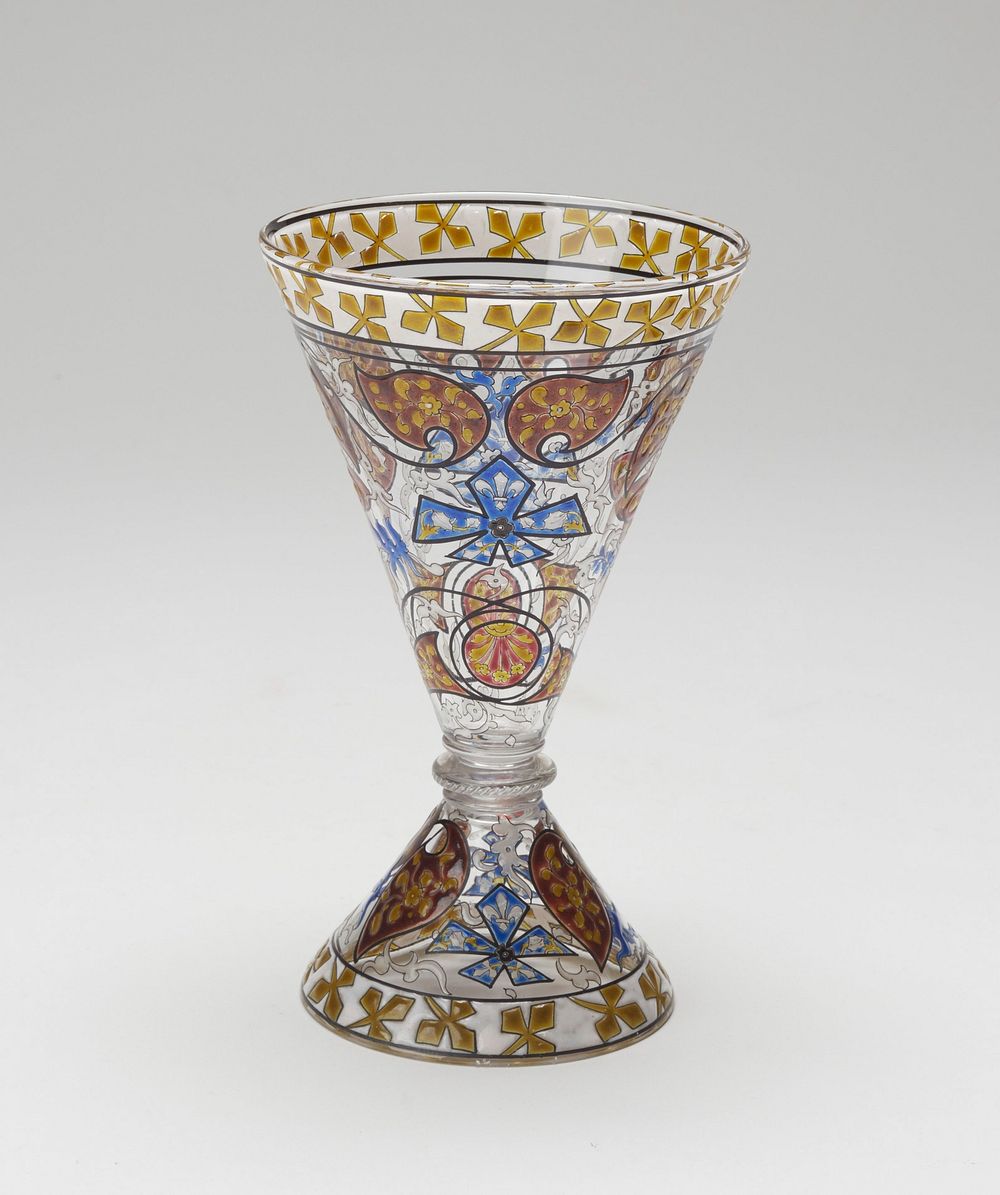 Blown glass, cone shaped bowl, clear stem. Bowl and base richly enamelled in color, predominantly blue, in Near Eastern…