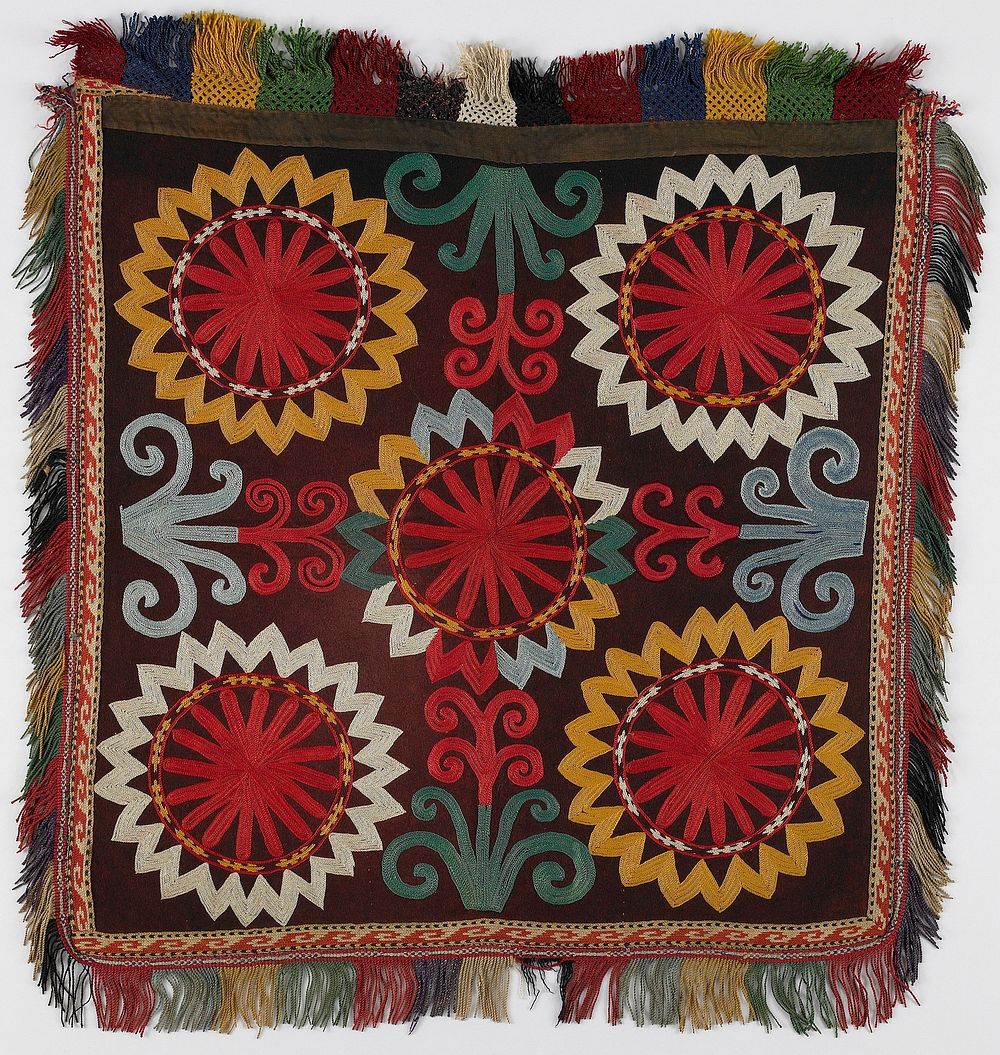 square panel; brown felt with multicolored (predominately red) embroidery of floral and sunburst motifs with central…