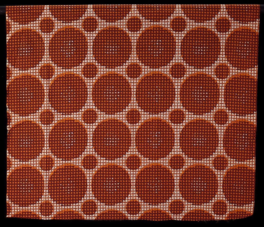 large and small orange circles covered with small brown oval print against basket weave pattern. Original from the…
