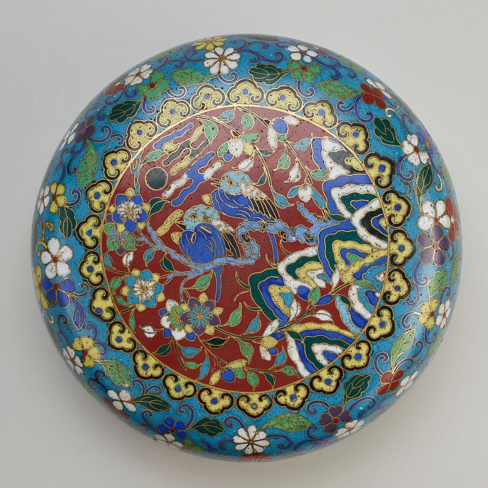 lozenge-shaped box on raised foot; blue ground and interior; scrolling multi-colored flowers; central round medallion with…