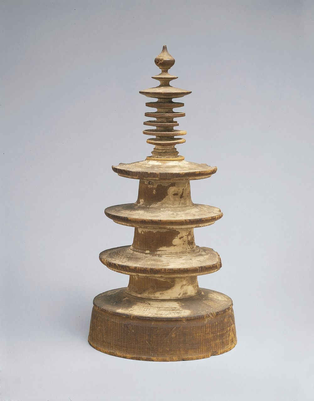 two-piece round pagoda with four disk-like sections; spindly finial sits on top; white pigment fragments. Original from the…