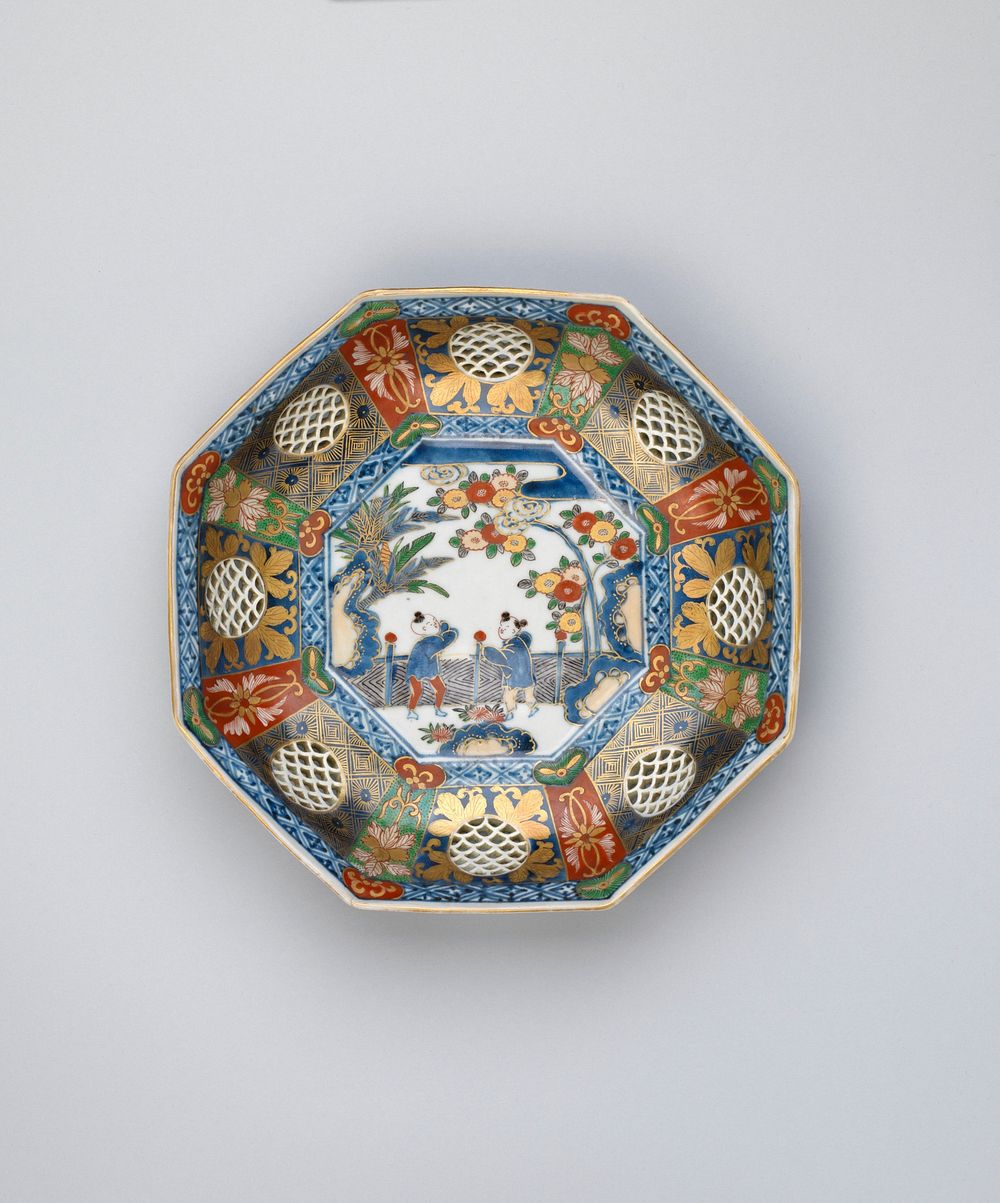 octagonal dish with central design of two Chinese children by a fence in a garden; border with circles pierced with wave…